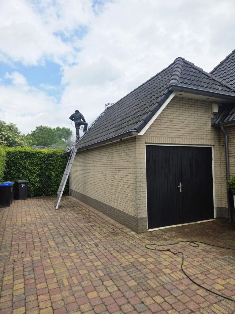 Vakman aan het werk op een pannendak tijdens de reiniging